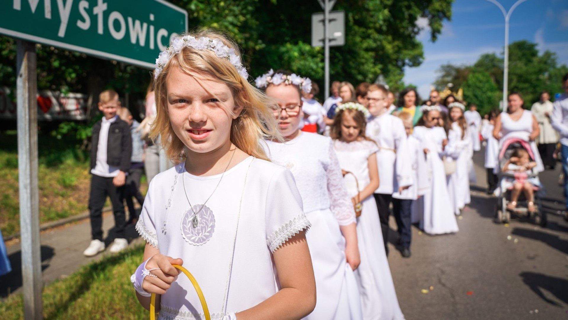 dziewczynka w białej komunijnej sukni idąca w procesji Bożego Ciała w Katowicach - Nikiszowcu