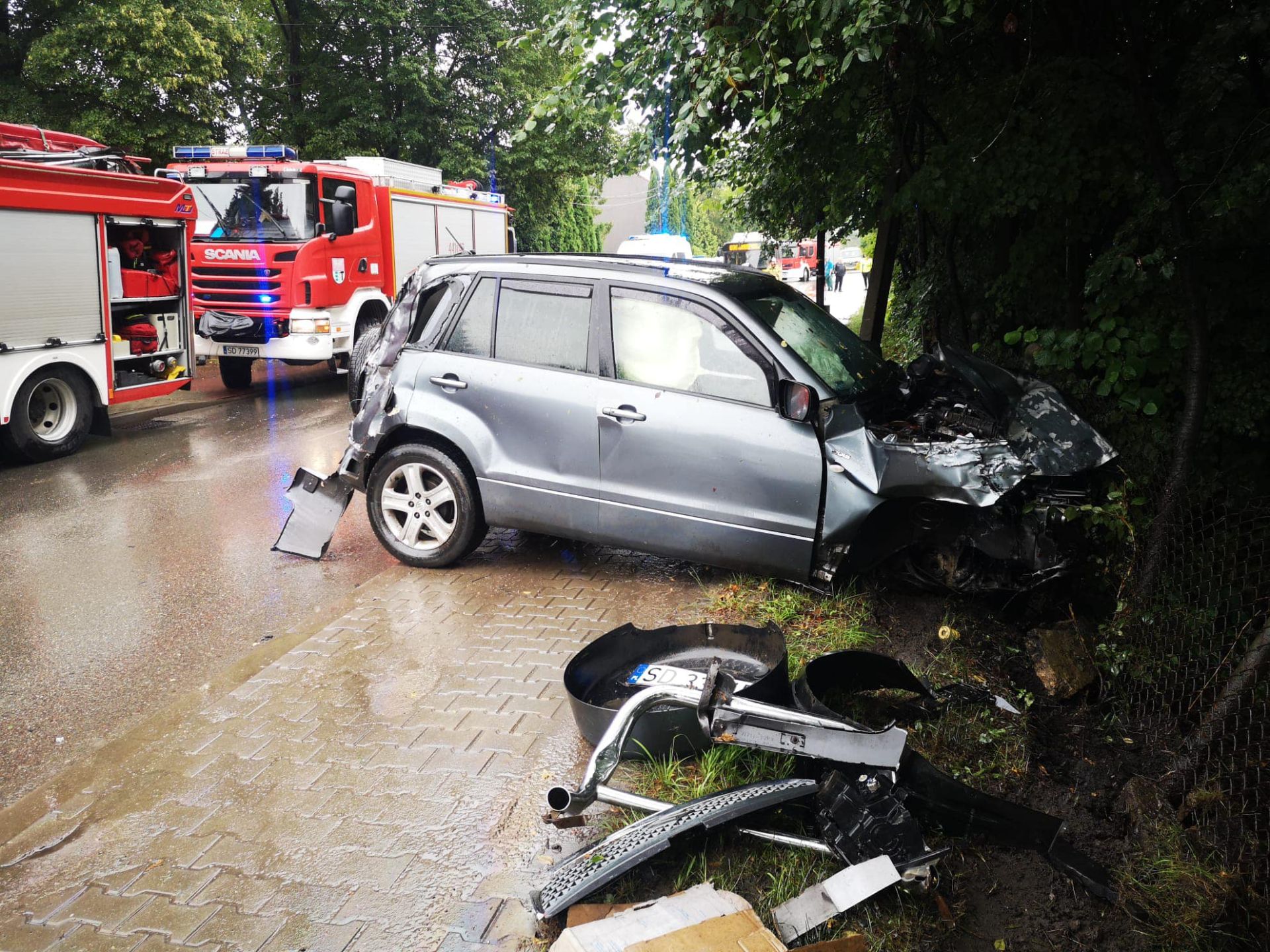 samochód wjechał w ogrodzenie posesji, w tyle wozy straży pożarnej