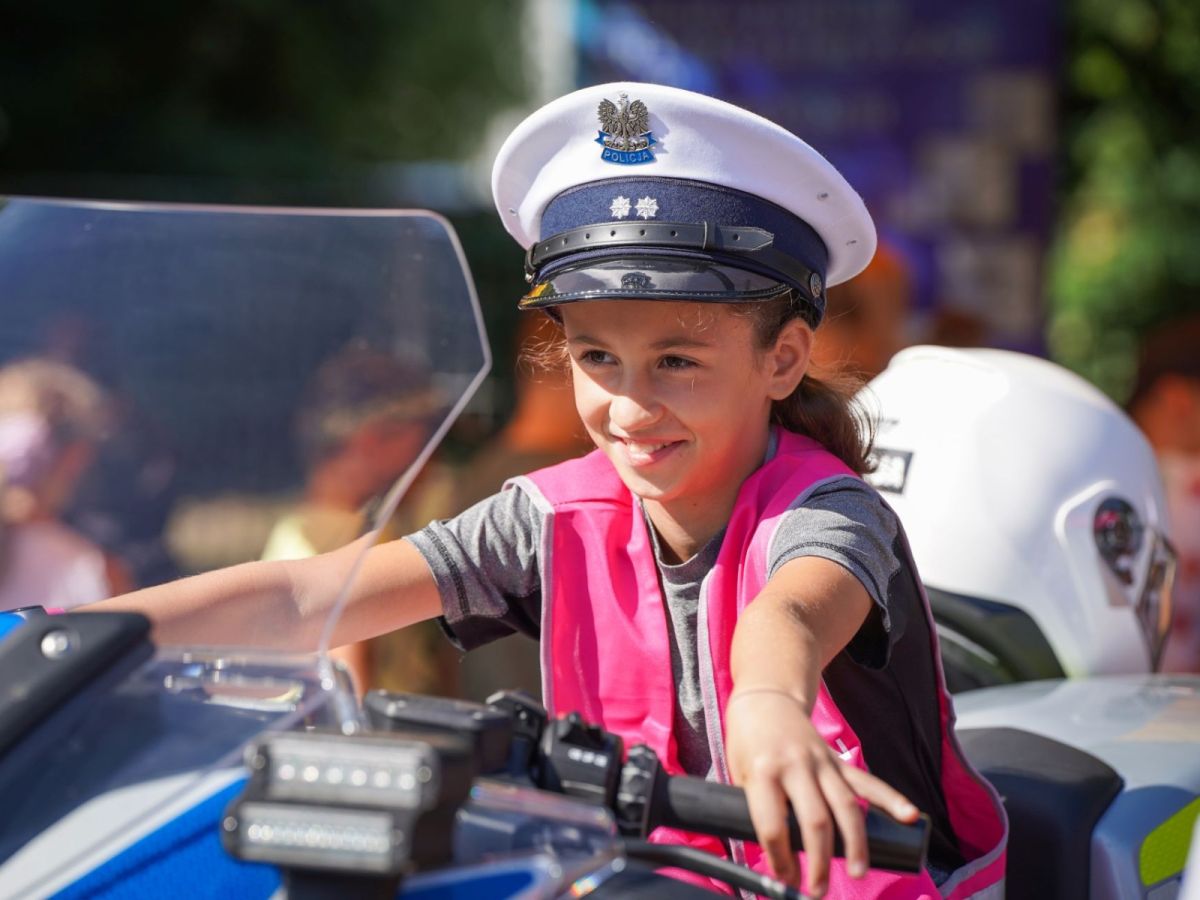 dziewczynka w czapce policjanta na motocyklu