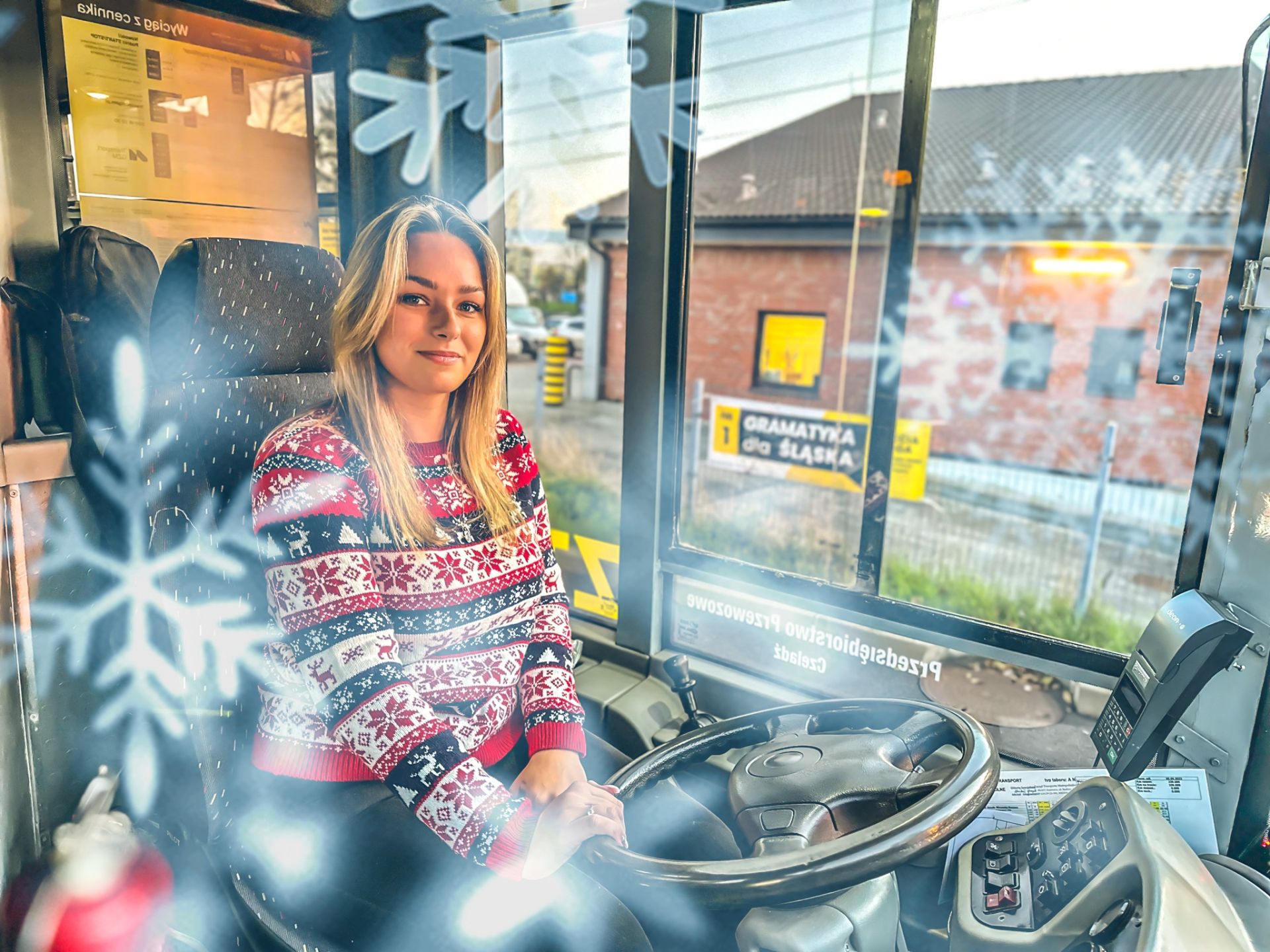 kobieta w świątecznym swetrze za kierownicą autobusu