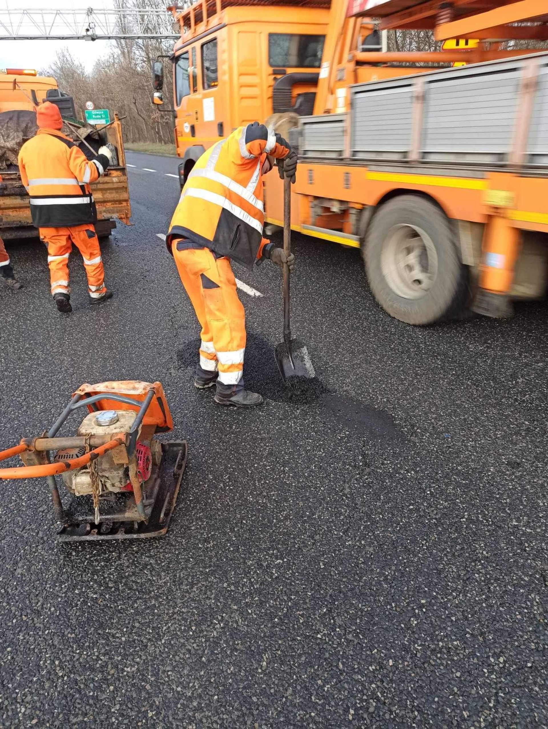 pracownik mzuim katowice łata dziurę w ziemi