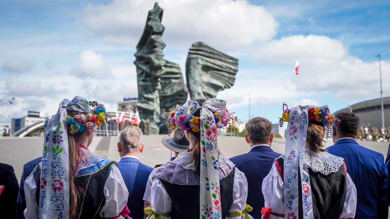 kobiety w ludowych strojach przed pomnikiem powstańców śląskich w Katowicach