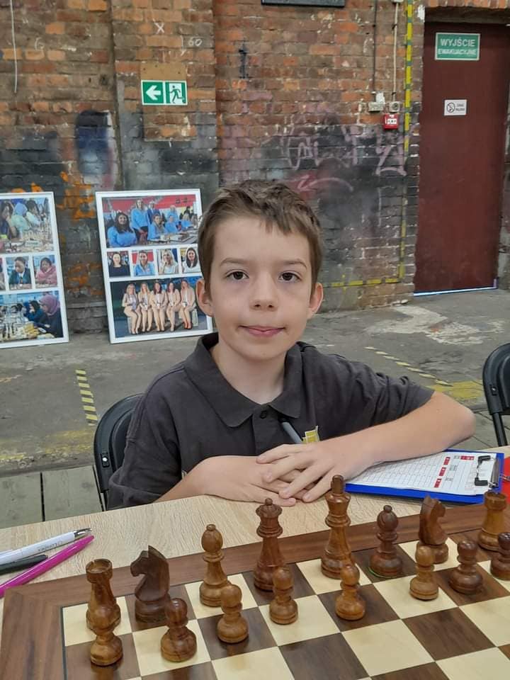 młody chłopak siedzi przy partii szachów