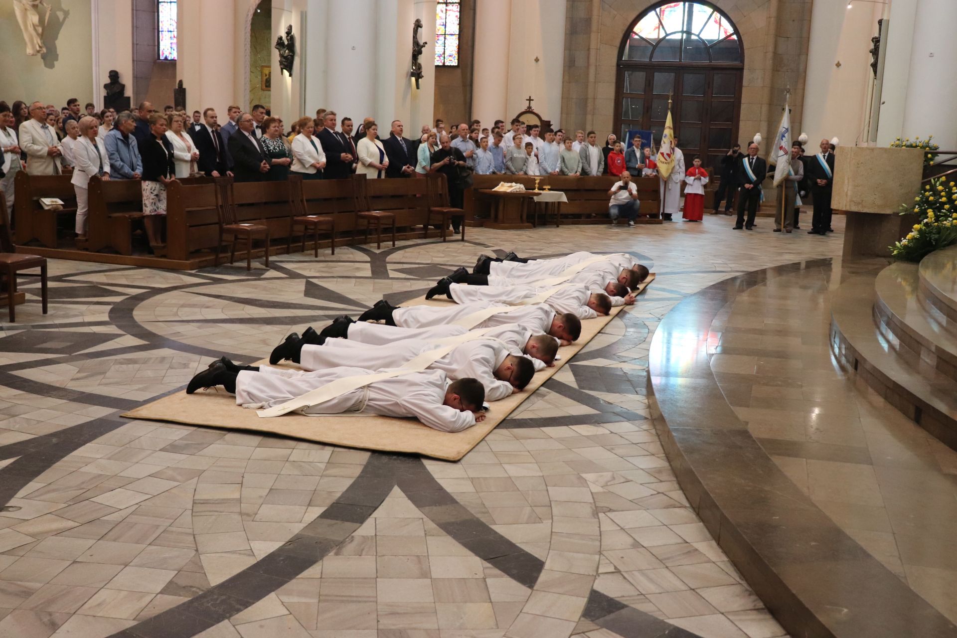 Fot. Mateusz Terech/WKATOWICACH.EU. Diakoni przed święceniami leżą w postawie najwyższego uniżenia przed ołtarzem katedry